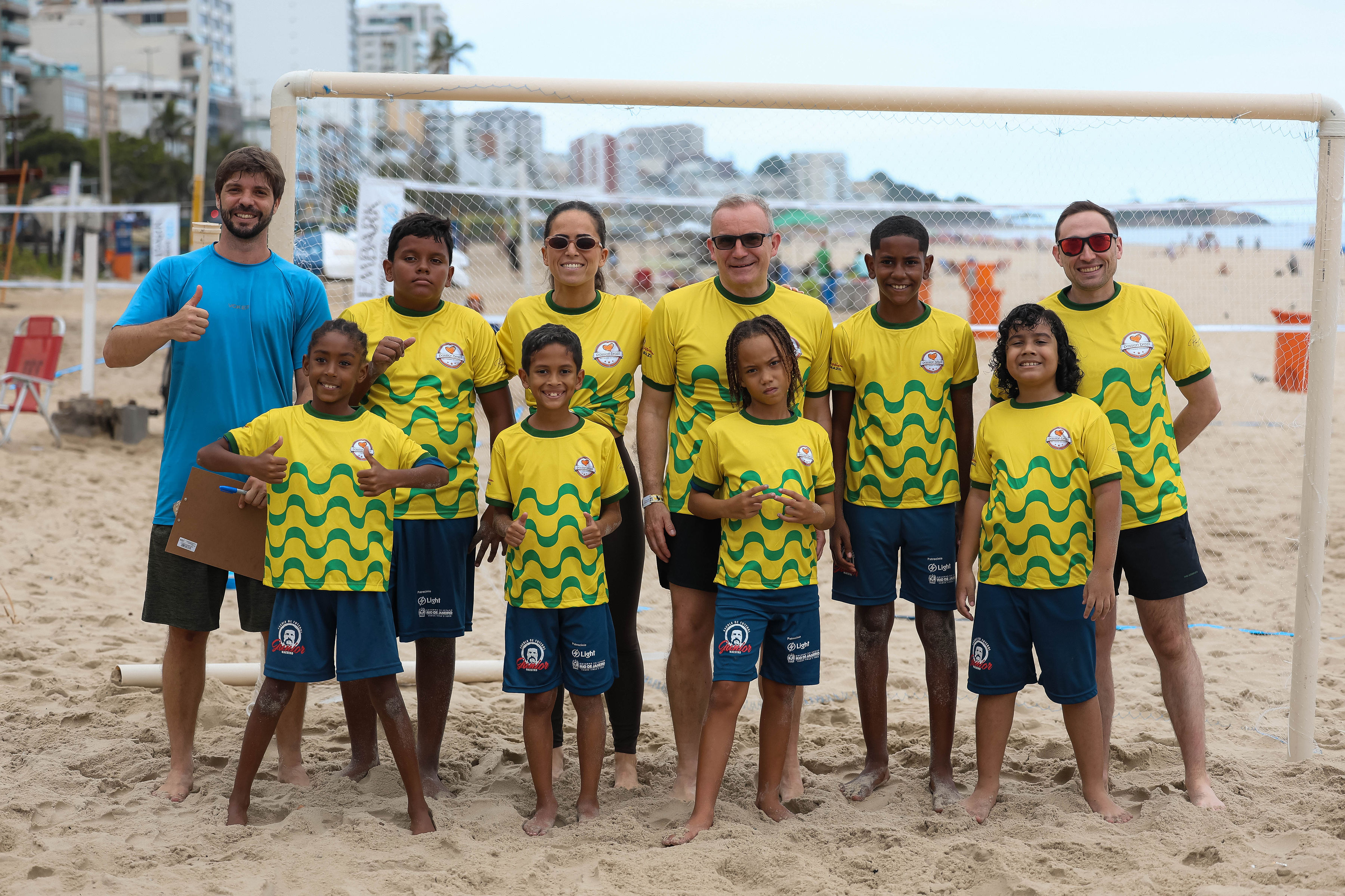 Football players and children together on the beach