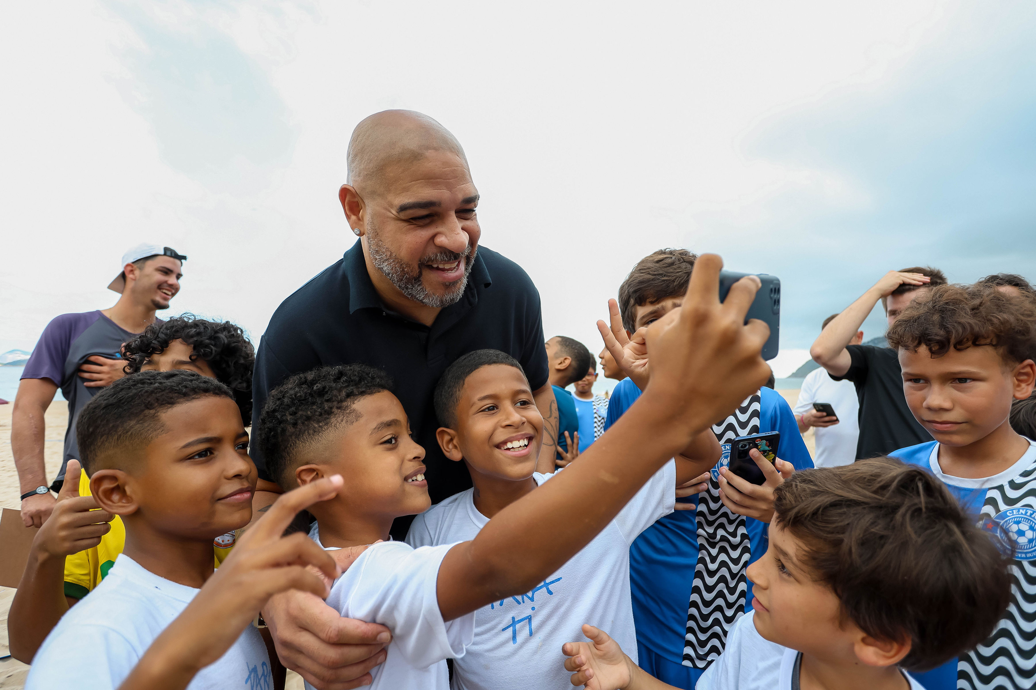 Children smiling and taking a photo with a guest at Chris Carnero Day